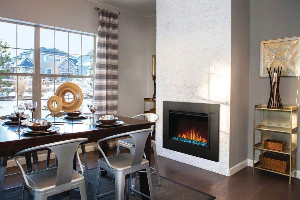 an electric fireplace set into the wall of the dining room in a bright modern home